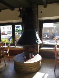 a large bell in a room with a table and windows at La Chrysalide in Étalle