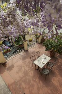 - une terrasse avec une table, des chaises et des fleurs dans l'établissement Antica Corte, à Busto Arsizio