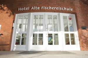 Hotel Alte Fischereischule في إكرنفورده: باب أبيض كبير في مبنى من الطوب