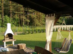 een veranda met een hangmat en een grill bij Cudodomek SPA w Mrozach Wielkich koło Ełku in Ełk