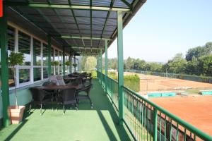 a patio with a table and chairs on a tennis court at Penzion Tenis Klub DEZA in Valašské Meziříčí