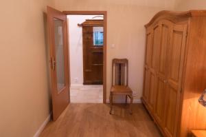 a hallway with a door and a chair in a room at Apartament Mundus in Sopot