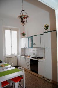 a kitchen with white cabinets and a table and a chandelier at B&B IL TABERNACOLO in Florence