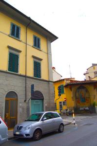 a silver car parked in front of a yellow building at B&B IL TABERNACOLO in Florence