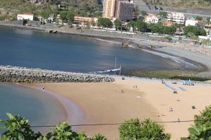 een strand met mensen op het zand en water bij Cozy and Bright Apartment in Machico