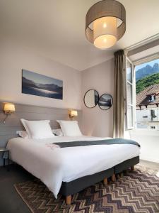 Säng eller sängar i ett rum på Hôtel Beau Site Talloires B SPA