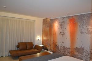 a living room with a chair and a wall with rusty paint at Hotel Marfil in San Antonio