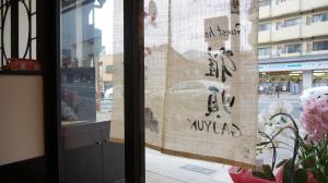 ein Fenster mit einem Schild an der Seite eines Gebäudes in der Unterkunft Guest House Ga-Jyun in Kyoto