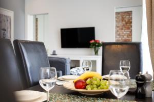 - une table avec une assiette de fruits et des verres à vin dans l'établissement Apartamenty Sienkiewicza - bezpłatny parking, centrum, park, fv, à Kielce