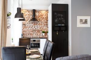 une cuisine avec une table et des chaises ainsi qu'un mur en briques dans l'établissement Apartamenty Sienkiewicza - bezpłatny parking, centrum, park, fv, à Kielce