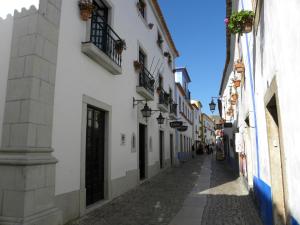 オビドスにあるRainha Santa Isabel - Óbidos History Hotelの白い建物と石畳の通りがある路地