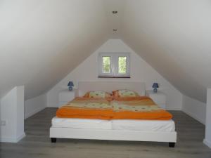 een slaapkamer met een wit bed met 2 kussens bij Schwedenhaus im Grünen in Oranienburg