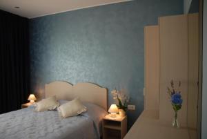 Schlafzimmer mit einem Bett mit blauer Wand in der Unterkunft Rooms Edda in Umag