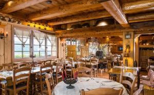 - un restaurant avec des tables et des chaises dans une salle dotée de plafonds en bois dans l'établissement Chalet Hotel Le Collet, à Xonrupt-Longemer