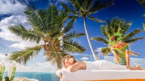 een man op een strandstoel op het strand bij Crystal Blue Lagoon Villas in Rarotonga