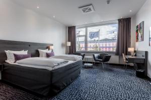 Cette chambre comprend un grand lit et un bureau. dans l'établissement ProfilHotels Mercur, à Copenhague