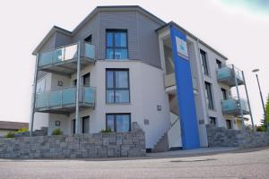 Un grand bâtiment blanc avec une porte bleue dans l'établissement SK Apartments -Apartment mit 2 Schlafzimmern, à Rust