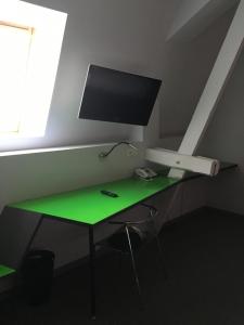 a green desk with a tv on top of it at La Chrysalide in Étalle