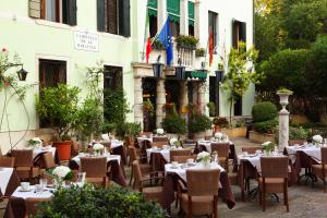 um restaurante com mesas e cadeiras em frente a um edifício em Pensione Accademia - Villa Maravege em Veneza