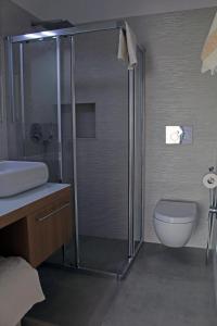 a bathroom with a shower and a toilet and a sink at Dimora Dioniso in Polignano a Mare