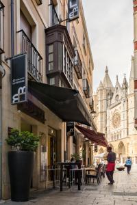 a person walking down a city street with a building at Hostal Albany in León