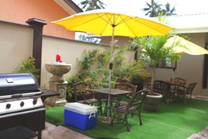 un patio con una mesa y una sombrilla amarilla en Lone Self-Catering Apartment, en Baie Sainte Anne