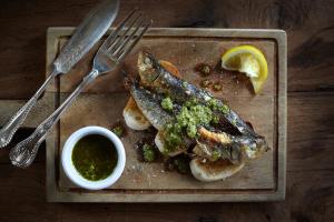 a plate of fish with a lemon and a dipping sauce at Master Builder's House Hotel in Beaulieu