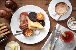 a plate of breakfast food on a table with a cup of coffee at Master Builder's House Hotel in Beaulieu