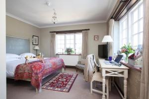 a bedroom with a bed and a desk with a computer at Master Builder's House Hotel in Beaulieu