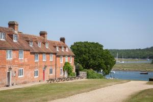 a large brick building next to a body of water at Master Builder's House Hotel in Beaulieu