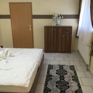 a bedroom with a bed and a cabinet and a rug at Boulevard Apartment in Raunheim