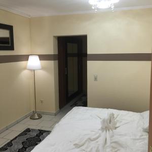 a bedroom with a white bed and a lamp at Boulevard Apartment in Raunheim