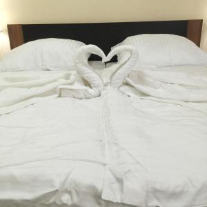 a bed with two swans making a heart at Boulevard Apartment in Raunheim