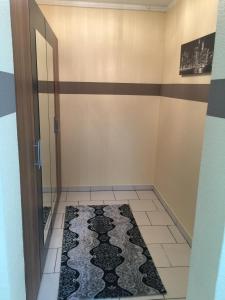 a bathroom with a door and a rug on the floor at Boulevard Apartment in Raunheim