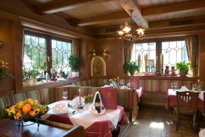 une salle à manger avec deux tables et quelques fenêtres dans l'établissement Hotel Dorfgasthof Schlösslstube, à Stuhlfelden