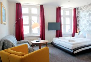 um quarto de hotel com uma cama e uma cadeira em Pension Klabautermann em Stralsund