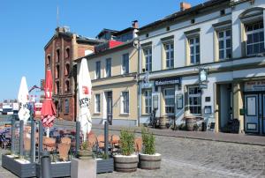 uma rua com cadeiras e guarda-sóis numa rua em Pension Klabautermann em Stralsund