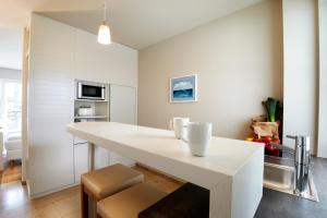 - une cuisine blanche avec une grande table et des chaises blanches dans l'établissement Im-Jaich Boardinghouse Bremerhaven, à Bremerhaven