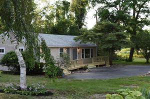 a white house with a porch and a driveway at Sandwich Inn and Suites in Sandwich