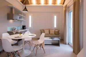 a kitchen and living room with a white table and chairs at Kotroni Villas in Finikounta