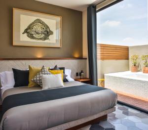 Schlafzimmer mit einem Bett und Blick auf eine Badewanne in der Unterkunft Hotel Criol in Querétaro