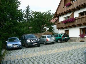 a group of cars parked next to a building at Apartmány U Vaců in Železná Ruda