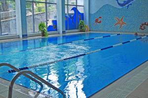 ein großer Pool mit blauem Wasser in einem Gebäude in der Unterkunft Aqua Hotel in Burgas City