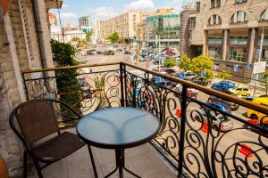 d'une table et d'une chaise sur un balcon offrant une vue sur la ville. dans l'établissement Mini hotel Non-Stop, à Kiev