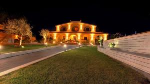 un grand bâtiment avec des lumières devant lui la nuit dans l'établissement Villa Sunset B&B/Apartments, à Fontane Bianche