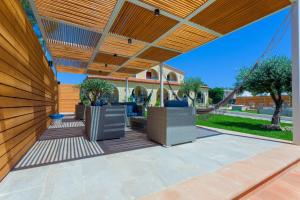 un patio extérieur avec une pergola en bois dans l'établissement Villa Sunset B&B/Apartments, à Fontane Bianche