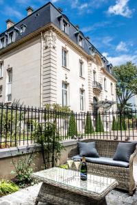 a building with a couch and a table in front of it at Les Suites du Champagne de Venoge in Épernay