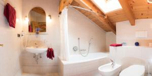 a bathroom with a sink and a tub and a toilet at Apartment Suliva in Santa Cristina in Val Gardena