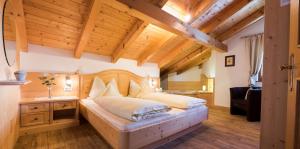 a bedroom with a large bed and a wooden ceiling at Apartment Suliva in Santa Cristina in Val Gardena