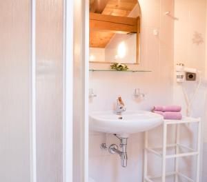 a white bathroom with a sink and a mirror at Apartment Suliva in Santa Cristina in Val Gardena